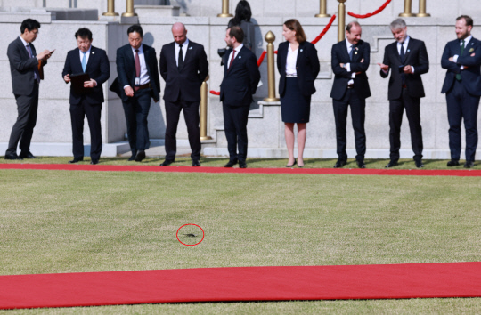 지난 24일 서울 용산 대통령실 앞 잔디마당에서 열린 안제이 두다 폴란드 대통령 국빈 방한 공식 환영식 행사장에 북한의 쓰레기풍선 낙하물 전단 1장이 떨어져 있다. 연합뉴스